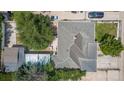 Birds-eye view of a home with an ashpalt shingle roof, mature trees, and a fenced yard at 6871 Locust St, Commerce City, CO 80022