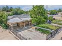 Aerial view of a well-maintained single-story home with a large backyard and mature trees at 6871 Locust St, Commerce City, CO 80022