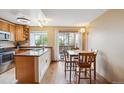 Eat-in kitchen features granite countertops, wood cabinets, and sliding doors to outdoor area at 7665 S Steele St, Centennial, CO 80122
