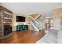 Bright living room with hardwood floors, fireplace, and staircase to the second floor at 7665 S Steele St, Centennial, CO 80122