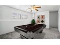 Basement game room with a vintage style billiard table, neutral paint, and a large window at 12065 E Kentucky Ave, Aurora, CO 80012