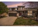 Charming two-story home with a well-maintained front yard, stone accents, and an attached two-car garage at dusk at 2749 Pemberly Ave, Highlands Ranch, CO 80126