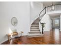 Grand foyer with hardwood floors, curved staircase, bench, and ample natural light showcasing a welcoming entrance at 2749 Pemberly Ave, Highlands Ranch, CO 80126