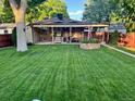 Expansive backyard with a covered patio, windmill feature, and well-manicured lawn at 2989 S Corona St, Englewood, CO 80113