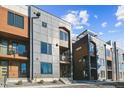Modern townhome exterior showcasing mixed material facade, balconies, and landscaped entryways under a bright sky at 3017 W 53Rd Ave, Denver, CO 80221