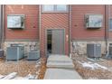 A close-up view of the front door, showing its details and design with heating/cooling units at 343 W Lehow Ave # 22, Englewood, CO 80110