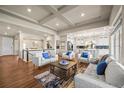 Inviting living room with coffered ceilings, hardwood floors, and an open concept layout to the kitchen and dining areas at 20783 E 50Th Pl, Denver, CO 80249