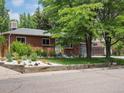 Attractive brick home showcasing lush front lawn, decorative rock features, and vibrant garden bed at 10109 W 68Th Ave, Arvada, CO 80004