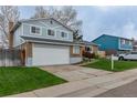 Well-kept home featuring an attached two-car garage and a neatly manicured lawn at 9340 W Burgundy Ave, Littleton, CO 80123