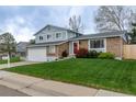 Lovely home featuring a green lawn, brick accents, and an attached two-car garage at 9340 W Burgundy Ave, Littleton, CO 80123