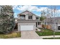 Inviting two-story home featuring a gray exterior, balcony, well-kept lawn, and convenient two-car garage at 5640 S Marshall St, Denver, CO 80123
