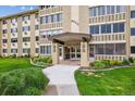 A close-up exterior shot of a condo's entrance featuring a walkway, landscaped greenery, and a well-maintained facade at 9625 E Center Ave # 5D, Denver, CO 80247