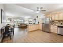 Bright, open kitchen-living room combo featuring wood floors, ample cabinet space, granite countertops, and stainless steel appliances at 9625 E Center Ave # 5D, Denver, CO 80247