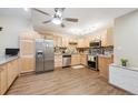 This kitchen showcases stainless steel appliances, light wood cabinets, granite countertops, and warm wood flooring at 9625 E Center Ave # 5D, Denver, CO 80247