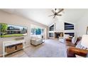 Bright living room offers a cozy fireplace, built-in shelves, and a large window at 982 E 130Th Cir, Thornton, CO 80241