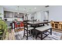 Stylish dining area with a large table, modern seating, and an adjacent kitchen for seamless entertaining at 9679 Waco St, Commerce City, CO 80022