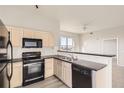 Bright kitchen with black appliances, light cabinets, and stylish countertops at 15475 Andrews Dr # 401, Denver, CO 80239