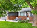 Inviting front porch with comfortable seating, framed by brick accents and colorful flower beds at 602 Birch St, Broomfield, CO 80020