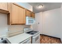 Efficient kitchen featuring wood cabinets, white appliances, and durable countertops at 2225 Buchtel Blvd # 105, Denver, CO 80210