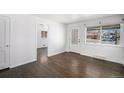 Bright living room with hardwood floors, a large window with natural light and an open doorway at 1654 Valentia St, Denver, CO 80220