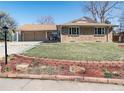 Well-maintained brick home with an attached two-car garage and landscaping at 2424 S Jasmine St, Denver, CO 80222