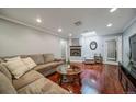 Inviting living room featuring hardwood floors, a cozy fireplace, and comfortable seating at 2424 S Jasmine St, Denver, CO 80222