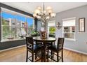Elegant dining room with large windows, hardwood floors, and stylish lighting fixture at 476 S Saulsbury St, Lakewood, CO 80226
