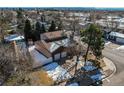 Aerial view of a home featuring a two-car garage, fenced yard, and mature trees at 5894 S Oak St, Littleton, CO 80127
