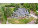 Aerial view of a beautifully landscaped home with mature trees, a well-maintained lawn and large lot at 7398 E Windlawn Way, Parker, CO 80134