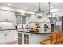 Bright kitchen features white cabinetry, stainless steel appliances, large windows and a center island at 7398 E Windlawn Way, Parker, CO 80134