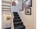 Carpeted staircase with white railings and neutral walls decorated with framed artwork at 1513 48Th St # 7, Boulder, CO 80303