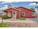 Charming red home with stone chimney, inviting entrance, and well-maintained landscaping at 8424 Everett Way # A, Arvada, CO 80005