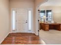 Bright entryway features gleaming hardwood floors, a white front door with sidelights, and an adjacent office at 17138 Moorside Dr, Parker, CO 80134