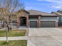Charming single-Gathering home boasts a brick facade, three-car garage, and mature landscaping at 17138 Moorside Dr, Parker, CO 80134