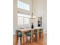 Bright dining room with hardwood floors, modern chandelier, and large window at 10222 Gemstone Ct, Parker, CO 80134