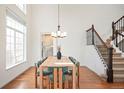 Dining room with hardwood floors, modern chandelier, and adjacent staircase. Large window at 10222 Gemstone Ct, Parker, CO 80134