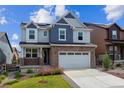 Two-story home featuring brick details and a white garage door with well-maintained landscaping at 9807 Rosalee Peak St, Littleton, CO 80125