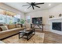 Cozy living room with a fireplace, plush sofa, and large windows offering plenty of light at 9807 Rosalee Peak St, Littleton, CO 80125