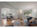 Open living room with hardwood floors, a dining area, and a view into a modern kitchen at 1439 Dexter St, Denver, CO 80220