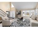 Bright living room featuring vaulted ceilings, fireplace, neutral color palette, and large windows at 8182 Sweet Water Rd, Lone Tree, CO 80124