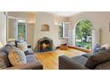 Cozy living room with a decorative fireplace, light wood floors, and an arched window with shutters at 1040 S Elizabeth St, Denver, CO 80209
