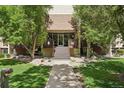 Charming building entrance with a well-kept garden and landscaped walkway to the front door at 3465 S Poplar St # 305, Denver, CO 80224