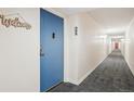 Well-lit hallway features neutral paint, carpet, and clear unit numbers at 3465 S Poplar St # 305, Denver, CO 80224