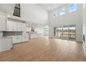 Bright living room featuring tall ceilings, wood floors, and sliding glass doors to the outdoor deck at 16537 Black Rose Cir, Parker, CO 80134
