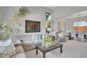 Open concept living room with views into the dining room, featuring neutral colors and large windows at 6379 Holman Ct, Arvada, CO 80004