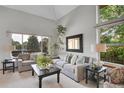 Bright living room with vaulted ceilings, large windows, and comfortable seating arrangement at 6379 Holman Ct, Arvada, CO 80004