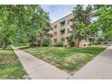 Exterior view of the home with surrounding grassy lawn and sidewalk access at 2100 N Franklin St # 20, Denver, CO 80205
