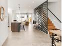 Open-concept living space featuring a modern kitchen, staircase, and stylish interior design elements at 4201 Vallejo St, Denver, CO 80211