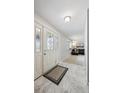 Bright foyer with marble floors, decorative glass front door, and view of the living room at 8201 Allison Ct, Arvada, CO 80005