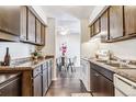 Kitchen boasts wood cabinets, laminate countertops, and a view into the dining area at 3339 S Monaco Pkwy # A, Denver, CO 80222